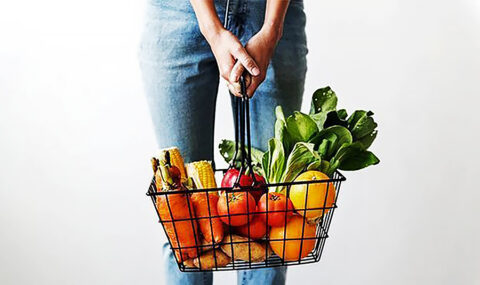 Nainen-kannattelee-vihanneksia-sisaltavaa-ruokakoria