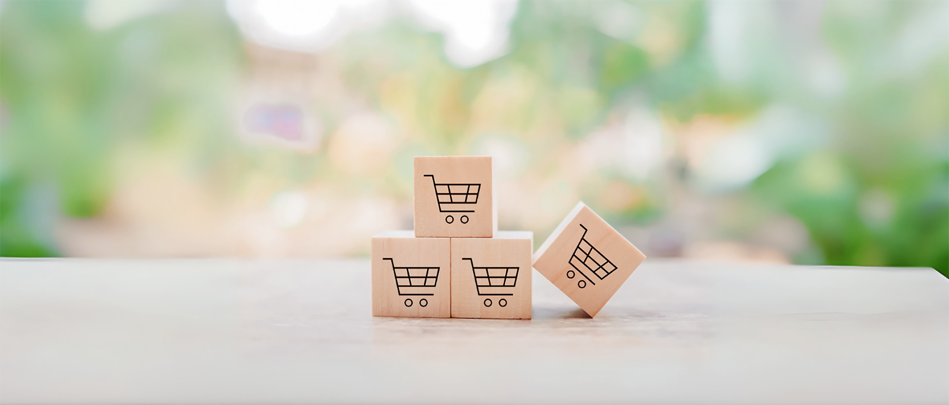 Pöydällä neljä puupalikkaa joissa ostoskorin kuva