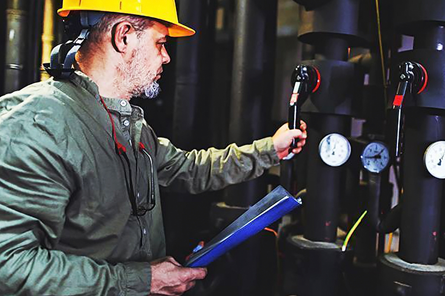 Huoltomies säätää lämmityslaitteistoa