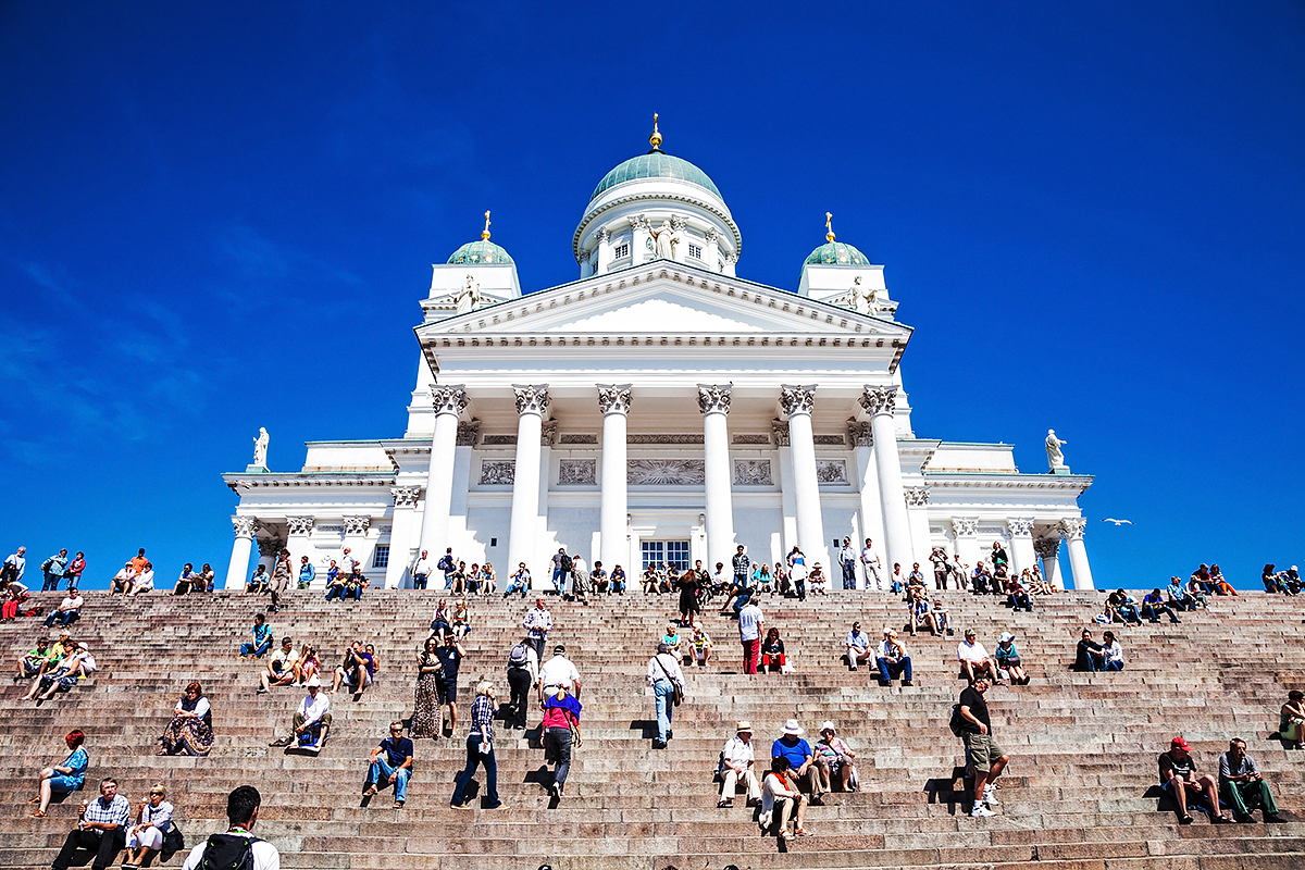 Väkijoukko istuu Suurkirkon portailla