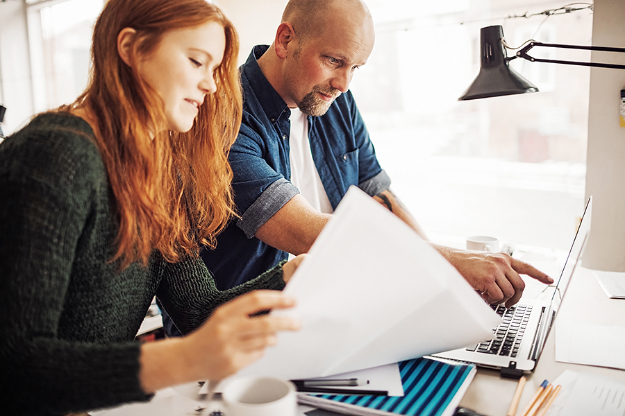 Mies ja nainen tyoskentelevat toimistossa tietokoneella