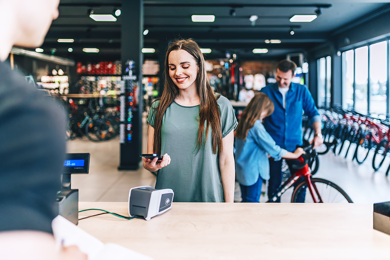 Nainen maksaa puhelimella pyörän vuokrauksesta.